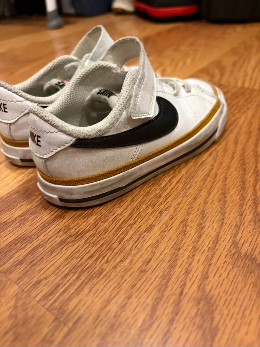 Nike Kids White Sneakers with Black Swoosh and Brown Accent